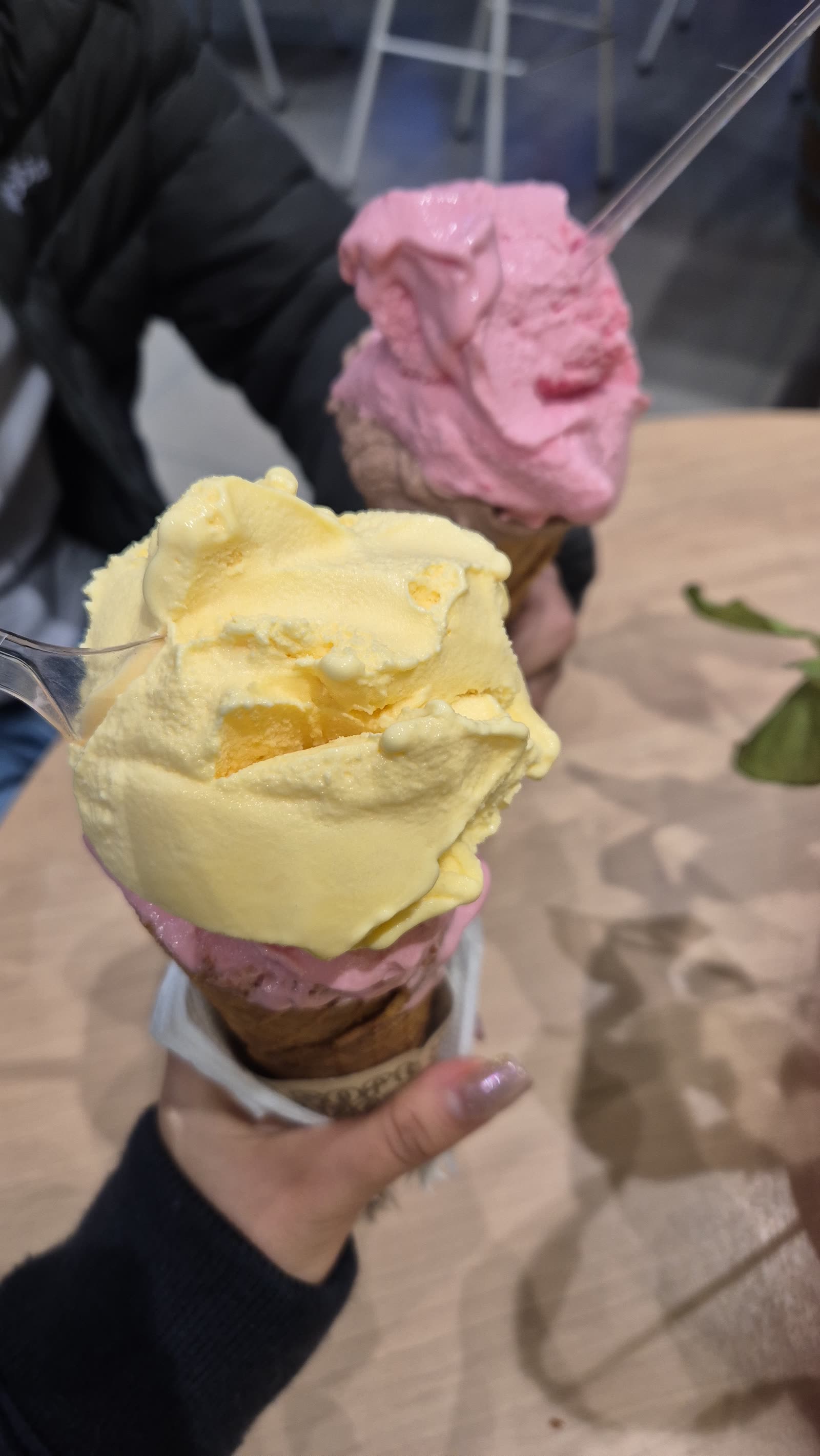 Un helado de dos bolas en la mano